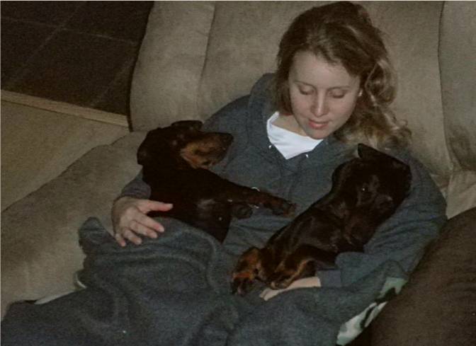 woman seated in a chair with her 2 dachshunds